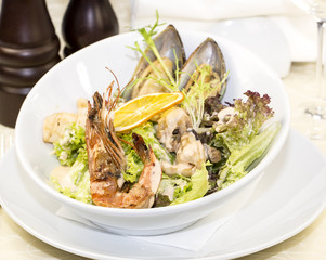 salad with vegetables and seafood on the table in a restaurant