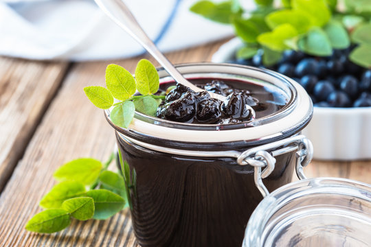 Blueberry jam in glass jar on wooden table
