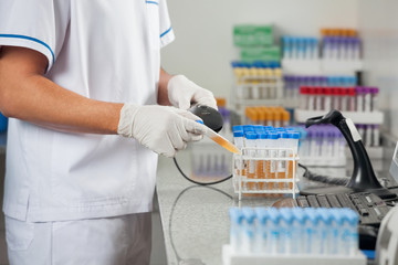 Technician Scanning Medical Sample In Laboratory