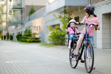 Young mother and her toddler girl riding a bicycle