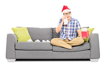 Obraz premium Sad man with Santa hat wiping his eyes from crying