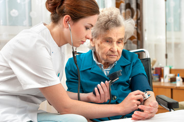 measuring blood pressure of senior woman