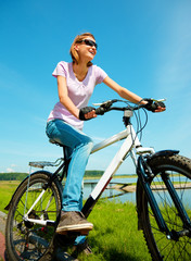 Young woman is sitting on her bicycle