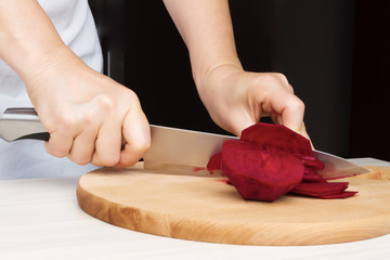 Woman chef prepare beets in the kitchen.