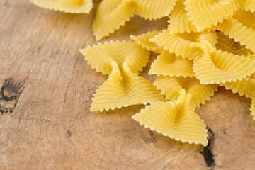 farfalle raw pasta on wooden table