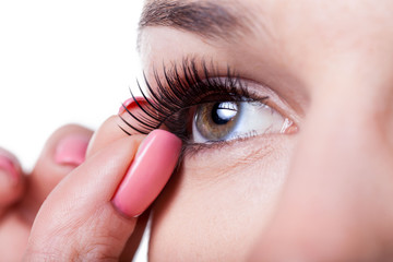 Woman applying false eyelashes