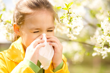 Little girl is blowing her nose