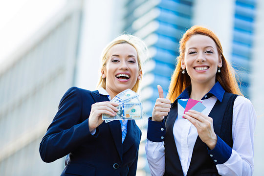 Happy business women holding credit cards, cash reward