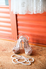 Wedding shoes, dress and pearl necklace. Wedding accessories.
