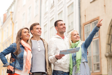 group of smiling friends with map and photocamera