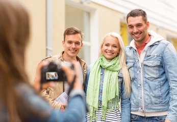 group of smiling friends taking photo outdoors