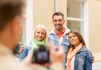 group of smiling friends taking photo outdoors