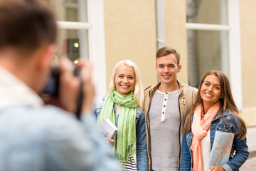group of smiling friends taking photo outdoors