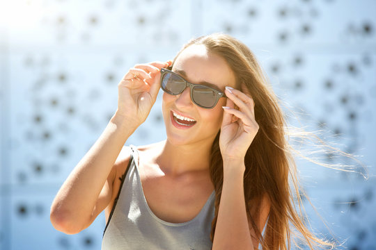 Carefree young woman smiling with sunglasses