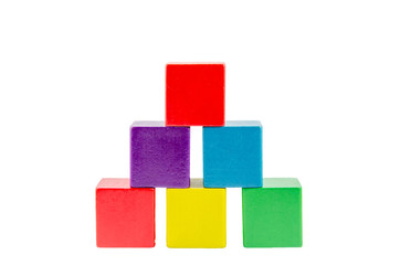Wooden colored building pyramid of cubes toys isolated on white