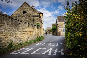 Keep Clear road sign with old lady. Cotswolds