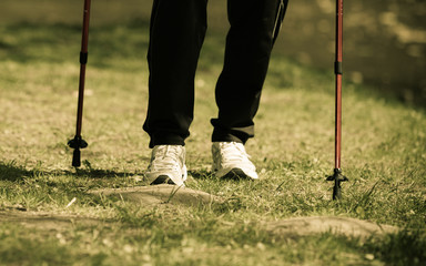 Nordic walking. Female legs hiking in the park.