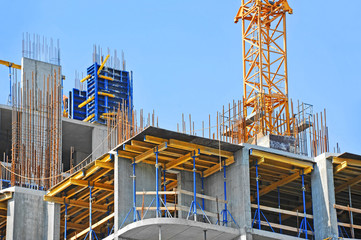 Crane and building construction site against blue sky - obrazy, fototapety, plakaty