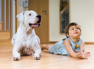 Cute female toddler on the floor with dog