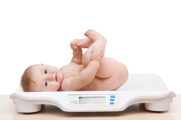 portrait of baby boy lying on scales.