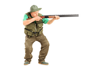 Mature hunter aiming at something with a gun