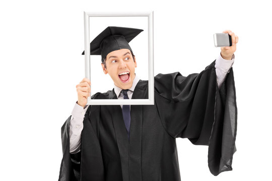 Graduate taking selfie behind a picture frame