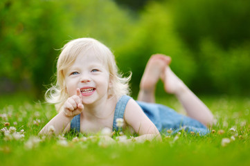 Cute little toddler girl laying in the grass