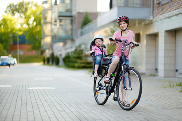 Young mother and her toddler girl riding a bicycle