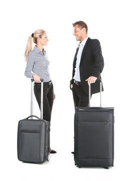 man and woman standing with luggage and talking.