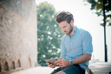 young handsome hipster modern man using tablet outdoor