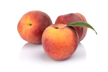 Fototapeta na wymiar Three peaches with leaf isolated on white