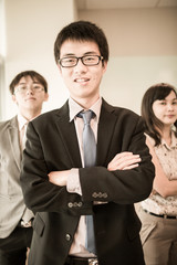 Happy business team with arms crossed at the office