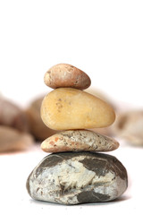 Fototapeta na wymiar Hill of four stones on a background of pebbles