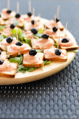 Closeup of snacks with salmon and black olives