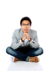 Happy asian man sitting on the floor over white background