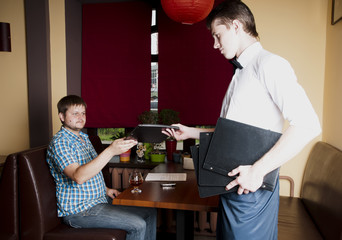 Man makes an order  to the waiter at a restaurant.