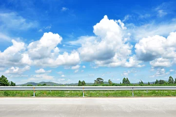 Fotobehang Beautiful roadside view with green hill and blue sky  © Atstock Productions