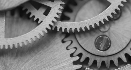 Black white background with metal cogwheels a clockwork. Macro