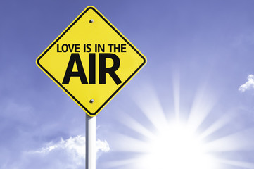 Love is in the Air road sign with sun background