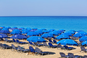 Sandy beach with blue parasols and sunbeds Kathisma Lefkada