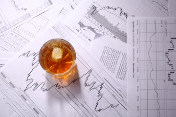 Glass of whiskey on charts