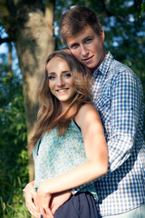 Fototapeta premium Young couple in nature on summer, looking into the camera