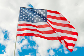 USA flag waving in the wind with white clouds on background