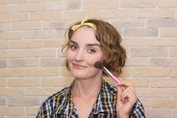 girl doing makeup with brush