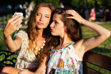 Two friends taking selfie by smartphone