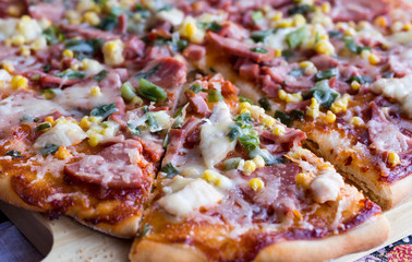 pizza with sausage, chicken, corn and cheese