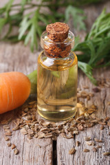 Medicated oil of carrot seeds in a glass bottle on the table