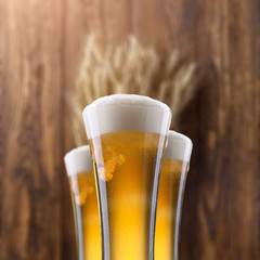 Glass of beer with wheat on wood