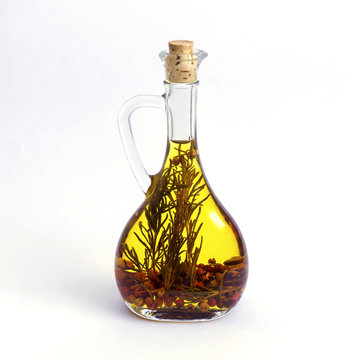 bottle with olive oil and herbs isolated on white background