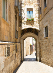Fototapeta na wymiar Arch over old narrow street of city. Girona